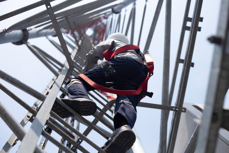 Telecommunications worker climbing tower