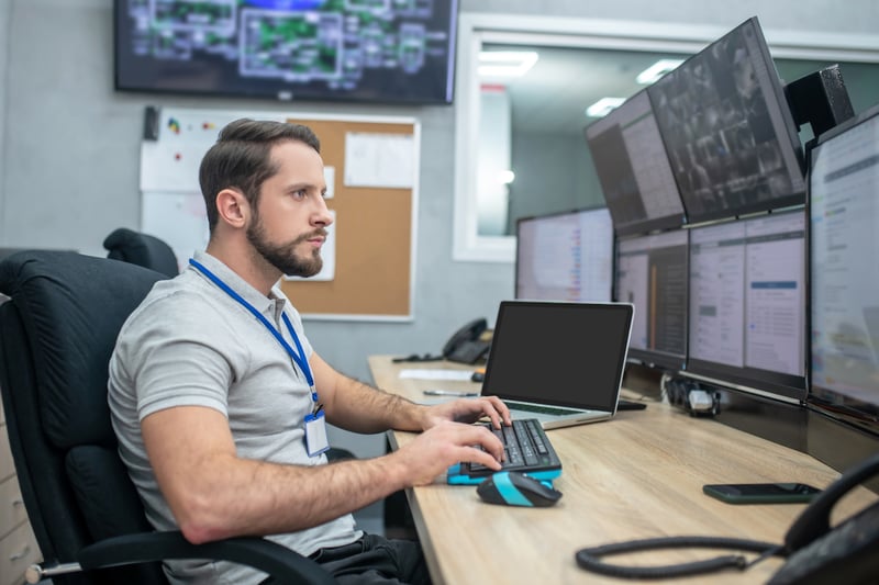 Man working at a desk with multiple screens