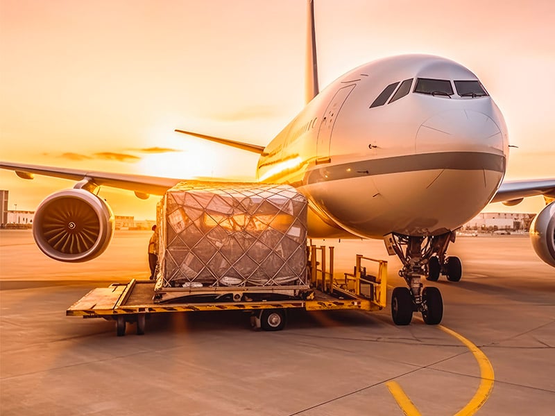 Closeup of a jet and cargo against a sunset