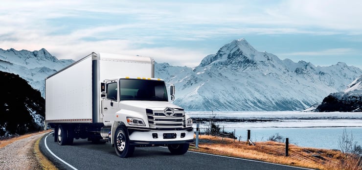 truck providing urgent shipping on a road with a mountain in the background