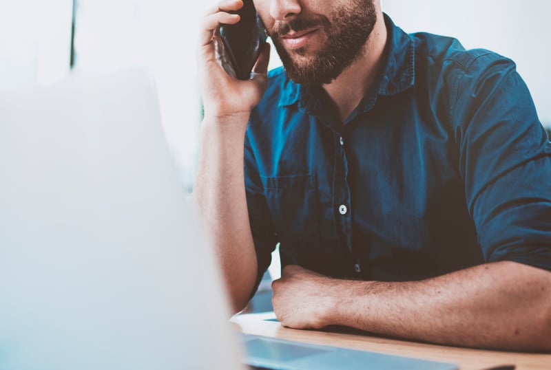 Man using the phone and a computer