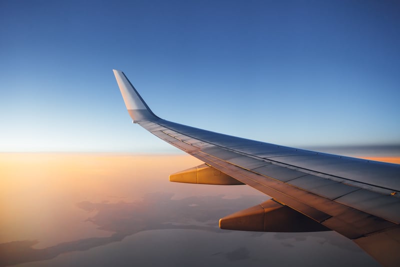 airplane wing against sunset sky background