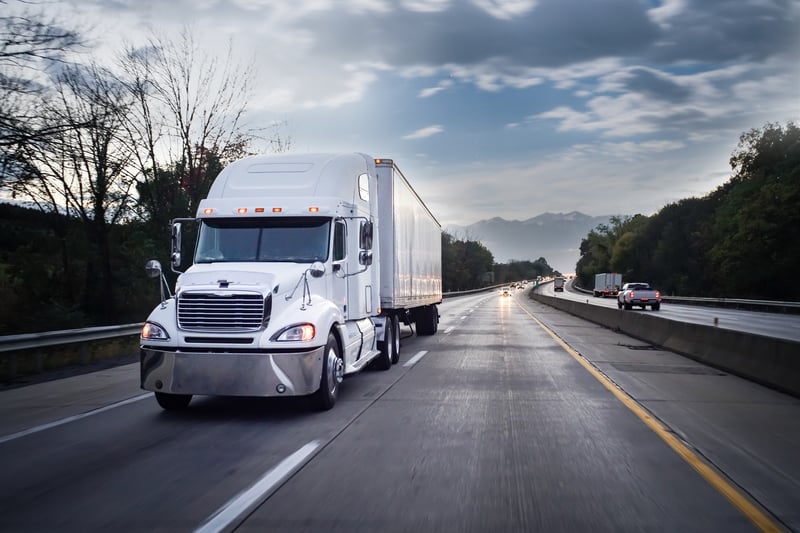 White 18 wheeler truck on highway at night