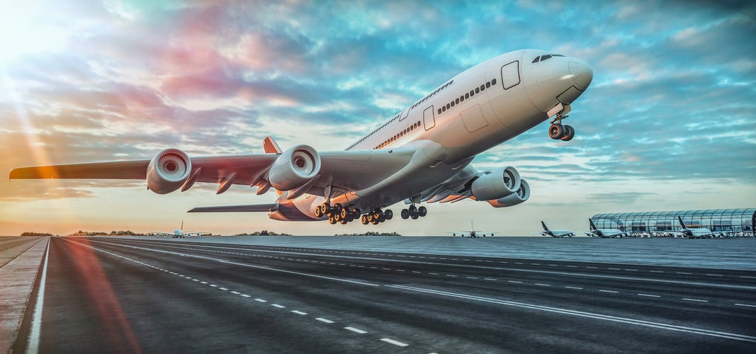 Airplane taking off at sunset