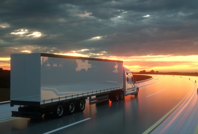 Large truck driving at dusk