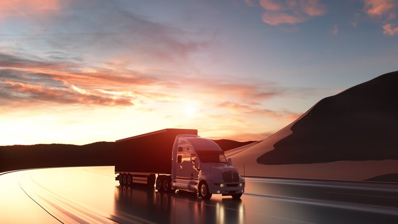 Semi truck driving sunset