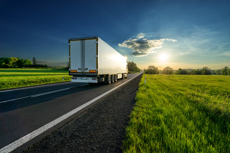 White truck driving on the asphalt road