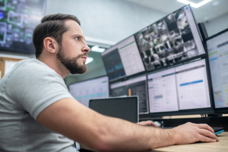 Man looking at computer screens focusing