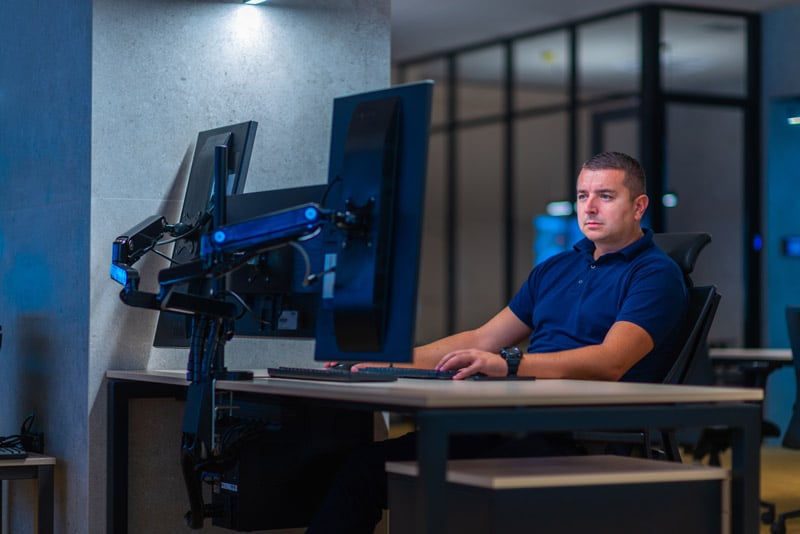 man working on computer with multiple screens